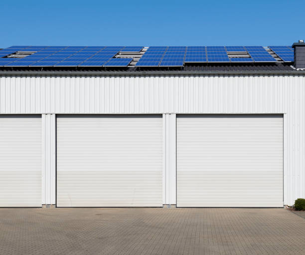 istock White rolling garage doors and solar panels of a warehouse 1215138521
