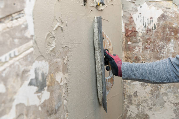 istock construction worker align the old bathroom wall with trowel and plaster 1215138727