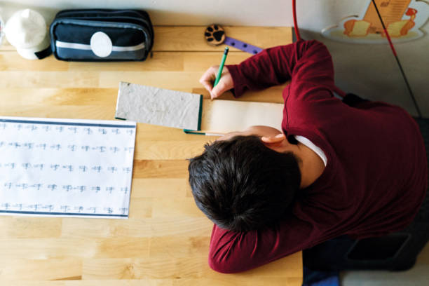 istock 6-7 years old child making homework at home. 1215139980