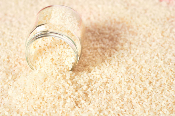 istock White rice poured out of glass jar. Copy space 1215145423
