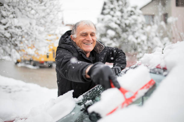 istock Senior man cleaning snow off his car 1215145539