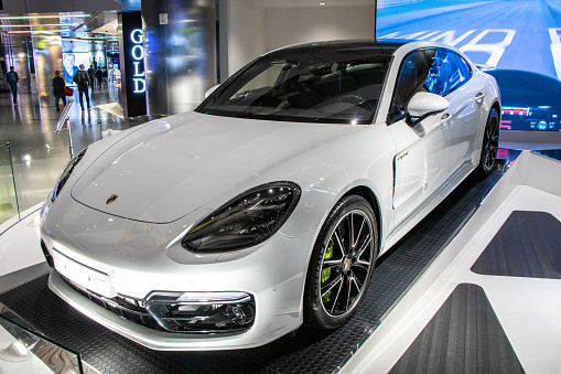 Doha, Qatar - A brand new Porsche hybrid sedan is featured in a dedicated vehicle display area inside the Grand Foyer of Hamad International Airport.