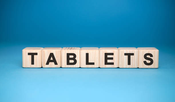 istock TABLETS word cube on a blue background. Medical concept. 1215146183