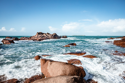 Pink granite coast on the Breton coast west of Perros-Guirec\nThe photo was taken at the Ploumanac'h lighthouse\nThe weather is variable and the sun highlights the color of granite\nThe tide is rising\nWe are at the lighthouse of Men Ruz on a small beach