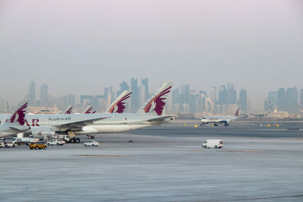 카타르항공 항공기, 멀리 도하 스카이라인과 함께 원격 스탠드에 주차 - qatar airways 뉴스 사진 이미지