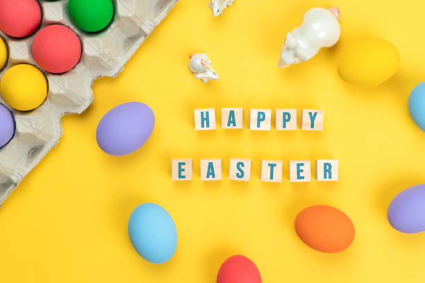istock Easter day little Bunny rabbit with decorated eggs on yellow background 1215148089
