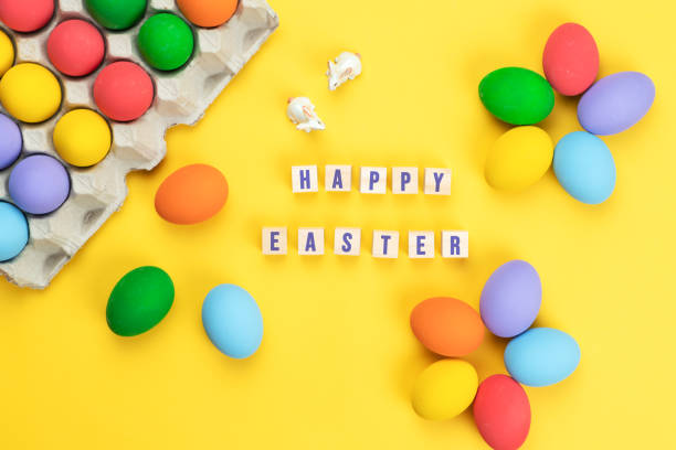 istock Easter day little Bunny rabbit with decorated eggs on yellow background 1215148108