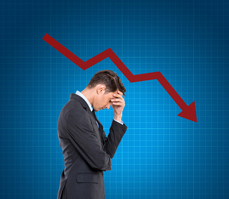 Worried businessman with head in hands during global financial crisis