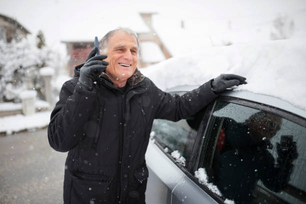 uomo anziano che parla allo smartphone in inverno - weather vane foto e immagini stock