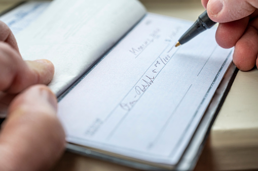 Closeup of a man writing a check.