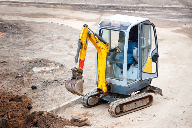 istock Tracked mini excavator breaks out old curbs before installing new curbs. The concept of using economical and compact equipment 1215154134