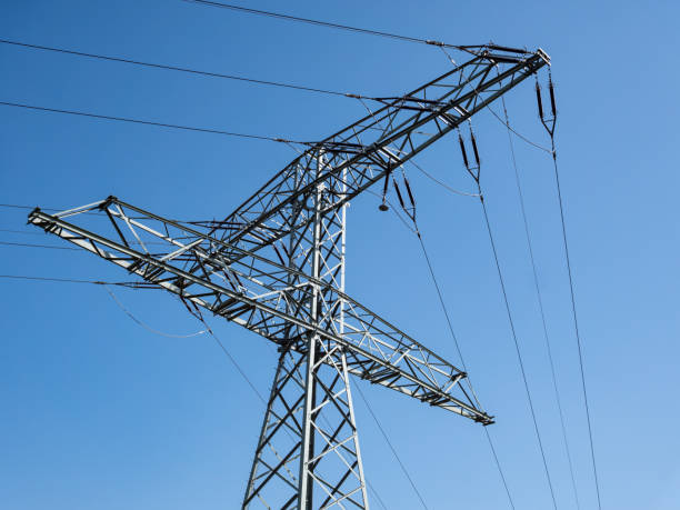 istock Electricity pylon with high voltage power lines blue background 1215154139