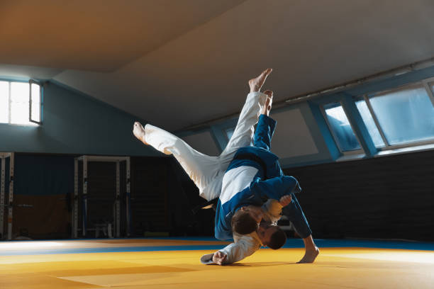 istock Two young judo fighters in kimono training martial arts in the gym with expression, in action and motion 1215159607