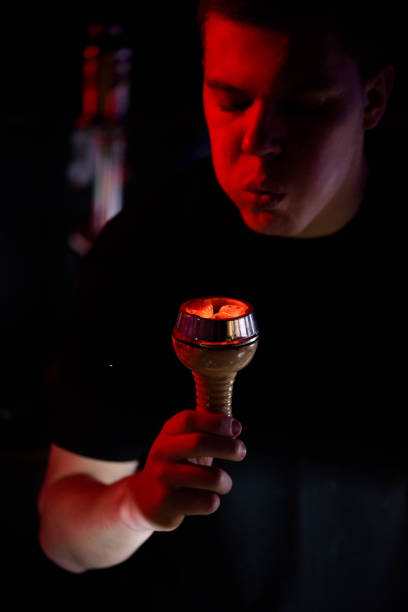 istock Shisha hookah, red hot coals. Man blows coals for sparks fly. 1215170091