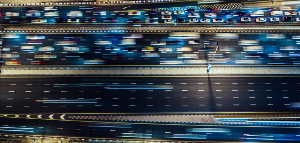 vista aerea dall'alto verso il basso del traffico cittadino su un'autostrada di notte - night cityscape dubai long exposure foto e immagini stock