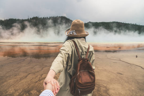 Rear View of Couple Holding Hands at Yellowstone Rear View of Couple Holding Hands at Yellowstone personal perspective standing stock pictures, royalty-free photos & images