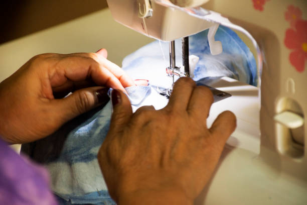 istock Thai old women working use sewing machine made fabric mask at workshop 1215173028