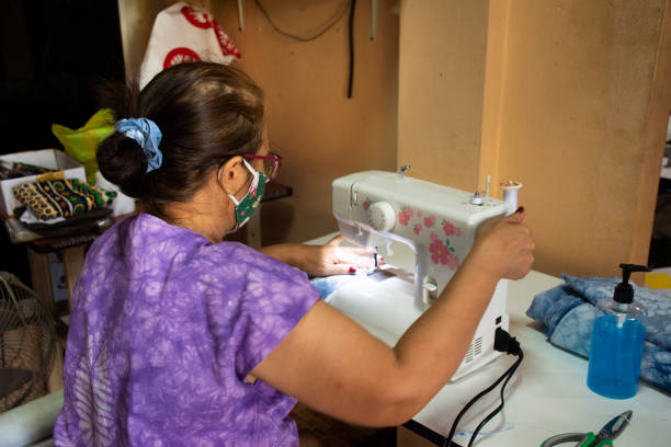 istock Thai old women working use sewing machine made fabric mask at workshop 1215173030