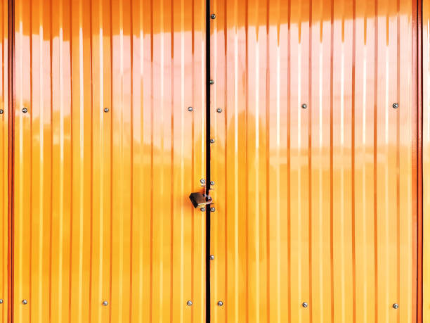 istock Full Frame Background of Locked Corrugated Yellow Shutter Door 1215178031