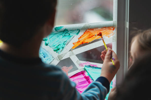 istock Brother & Sister Paint Window 1215178092