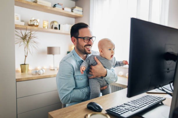 istock Young father working from home and holding his baby boy. 1215178138