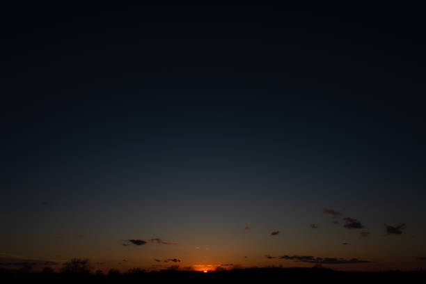 The setting sun dips below the horizon in Ankeny, Iowa.