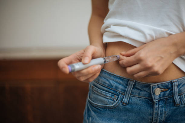 femme faisant l’injection d’insuline - insulin diabetes pen injecting photos et images de collection