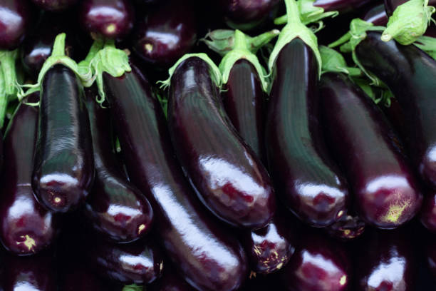 istock Pile of ripe fresh eggplants, close up. 1215178822