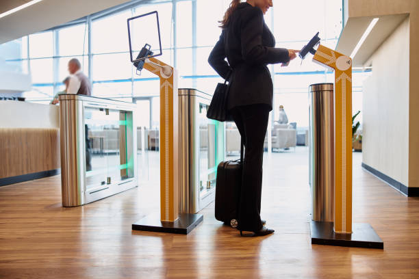 Elegant lady passing electronic turnstile at airport Stylish young woman using terminal for contactless payment at automated airport border control stock photo contactless airport stock pictures, royalty-free photos & images