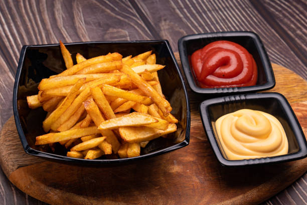 istock potatoes fries in a black dish and two sauces 1215186538