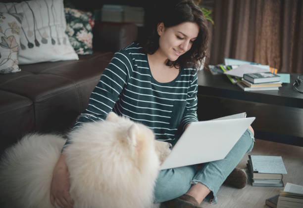 istock Beautiful young woman working at home with dog 1215186539