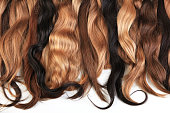 Mix of natural extensions hair: blond, red, brown. Strands of hair for hairstyles.