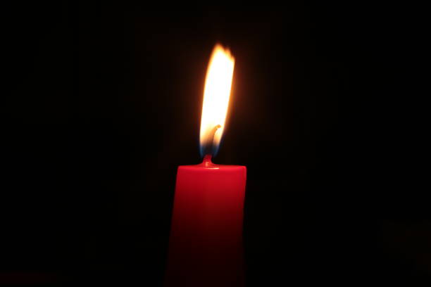 istock Mourning candle of sadness and longing. Festive fire macro background. 1215187670