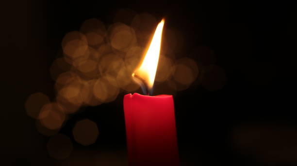 istock Mourning candle of sadness and longing. Festive fire macro background. 1215187702