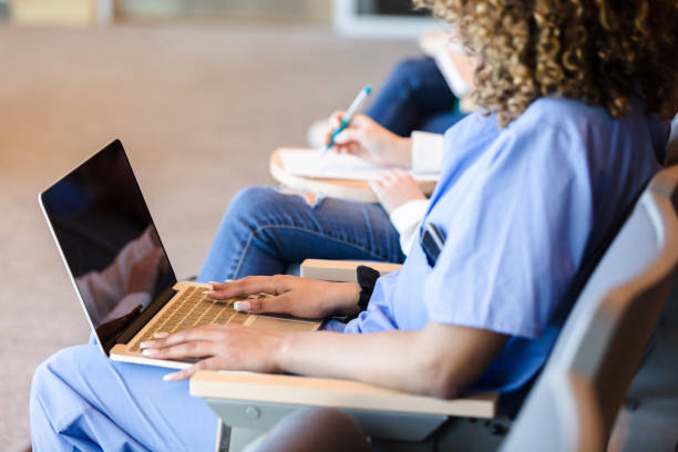 istock Unrecognizable female student uses laptop in class 1215187874