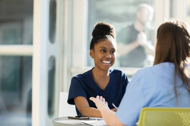 istock Young woman smiles as unrecognizable friend gestures and talks 1215187921