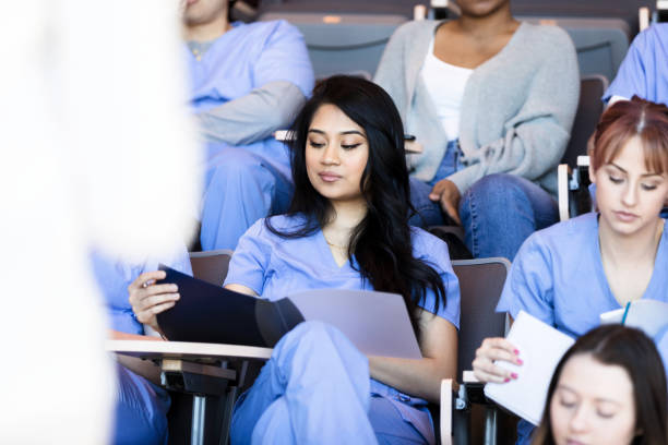 istock Young adult students follow along in notes as professor lectures 1215187957