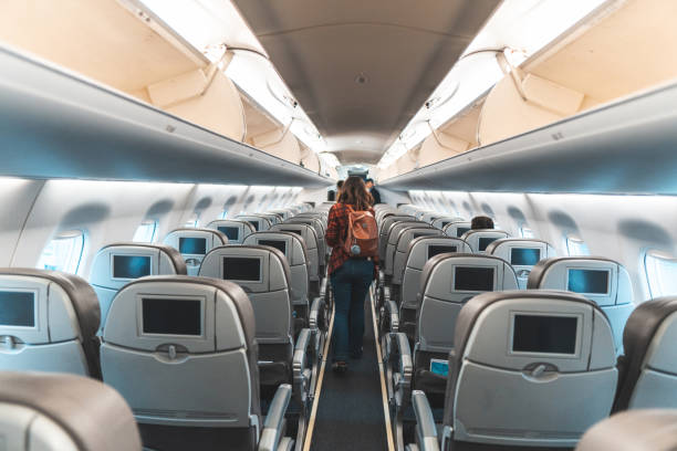 Woman walking the aisle on plane Walking, Air Vehicle, Airplane, Aisle, Journey passenger cabin photos stock pictures, royalty-free photos & images