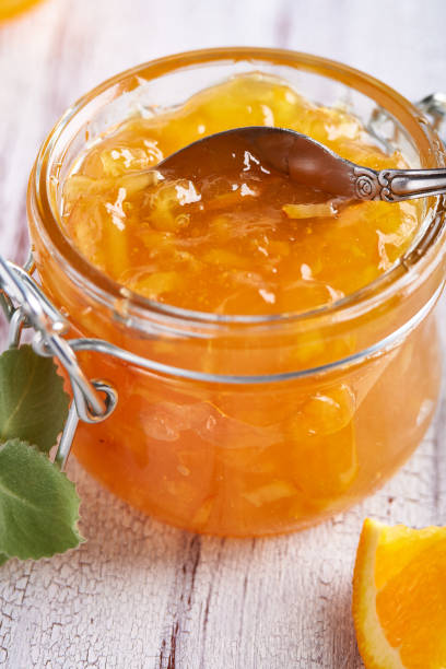 istock Homemade orange jam in jar on a white table. Food background Vertical 1215190171