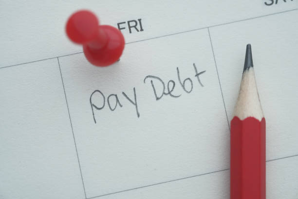 istock pay debt word written on calendar, top view 1215191315