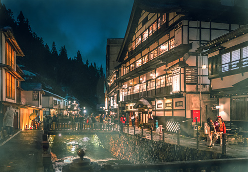 Yamagata; Japan - 27 Dec 2019: Tourists are traveling the Famous Ginzan onsen while snow is falling down.