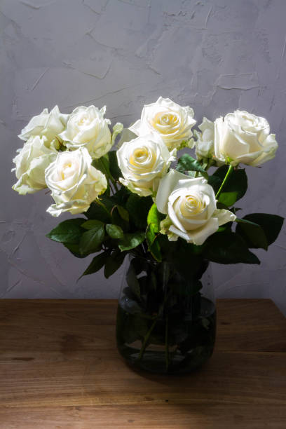 istock White roses in glass vase. 1215196194