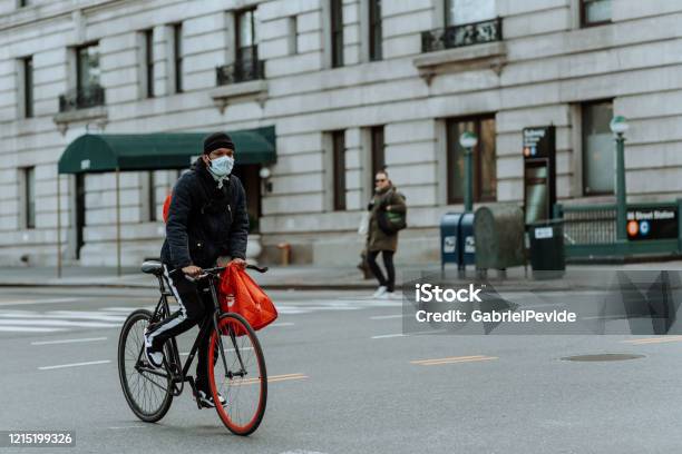 People Riding A Bicycle In Central Park Wearing Masks Stock Photo - Download Image Now