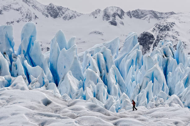 ein wanderer auf blauem eis am perito moreno gletscher, im nationalpark los glaciares im südwesten von santa cruz, argentinien. - serac stock-fotos und bilder