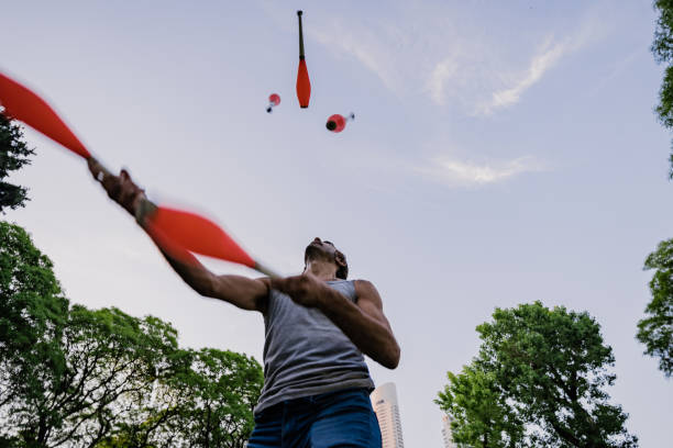 istock Man juggling with cones in park 1215201871