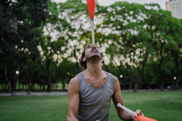 istock Man juggling with cones in park 1215202392