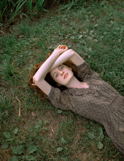 Portrait of an young Caucasian female sportsperson, lying on the exercise mat while relaxing after exercising in the nature