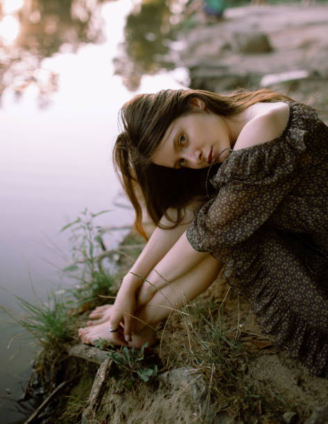 istock Young sensual woman sitting on grass 1215207571