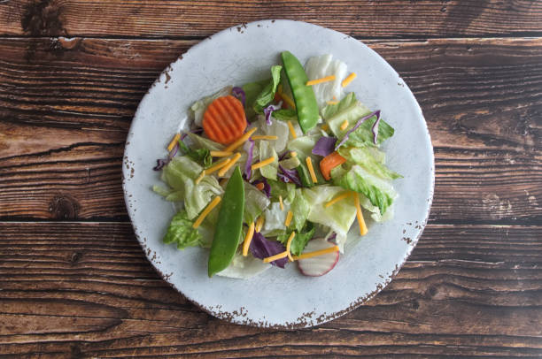 istock White plate with mixed salad on a wooden background 1215209451