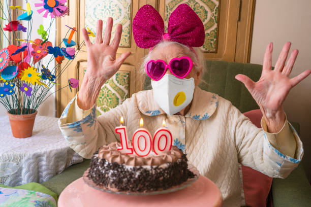 Coronavirus COVID-19 pandemic confinement with mask in 100 years old birthday cake old woman humor Coronavirus COVID-19 pandemic confinement mask 100 years old birthday cake old woman humor over 100 photos stock pictures, royalty-free photos & images